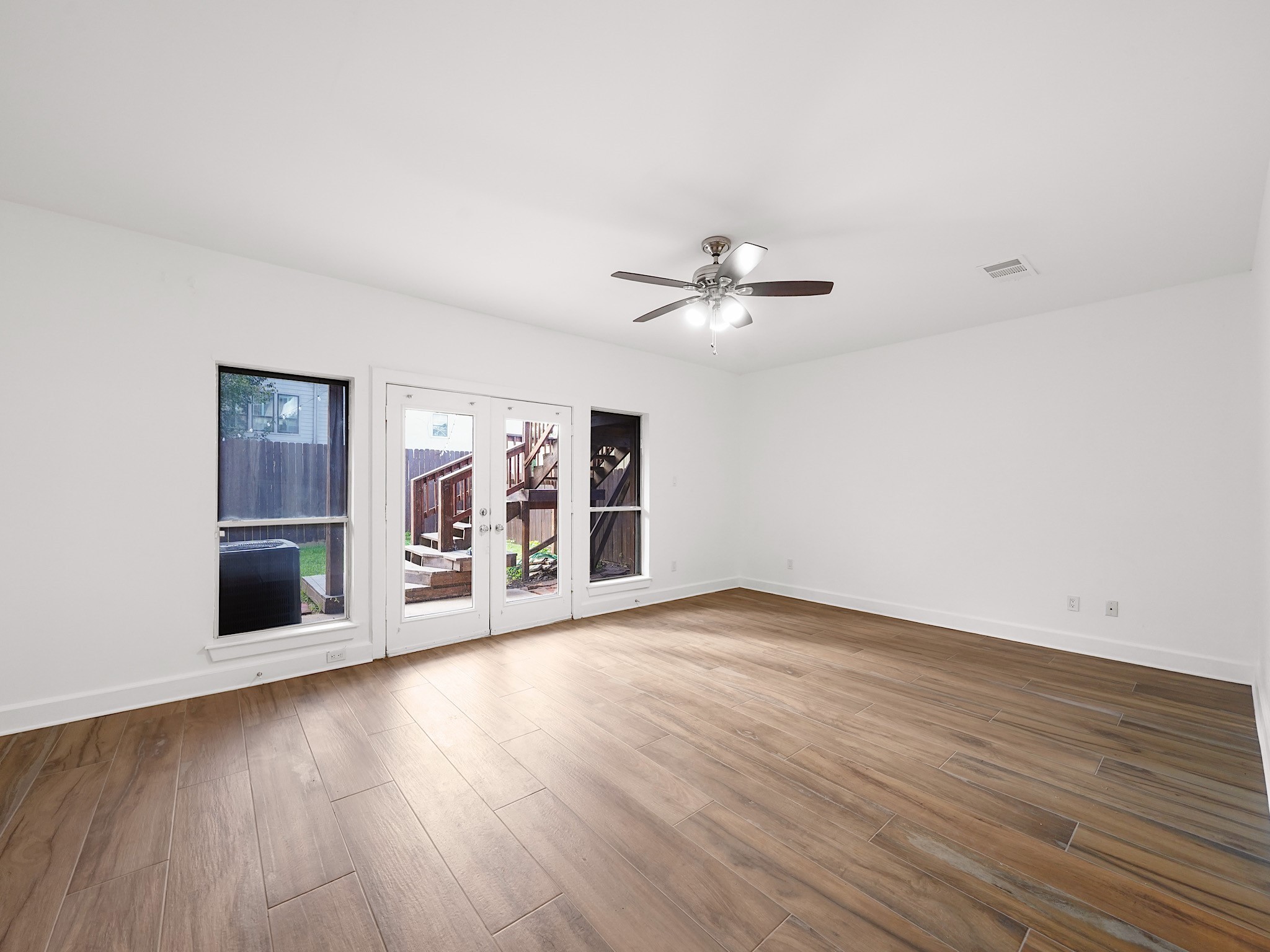907 Hartman Street Houston, TX 77007 - Photo 3 of 34 a view of an empty room with wooden floor and a window