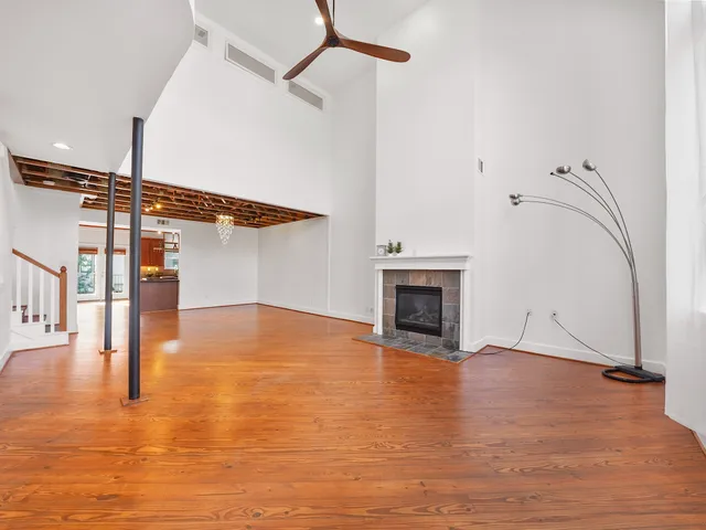 a view of empty room with wooden floor and fireplace