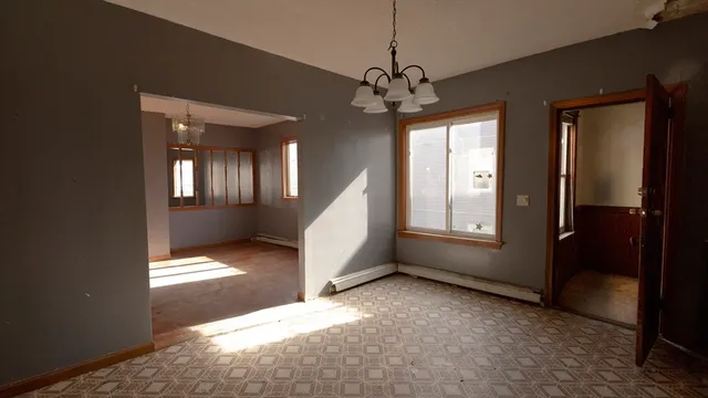 a view of a livingroom with a chandelier fan and windows