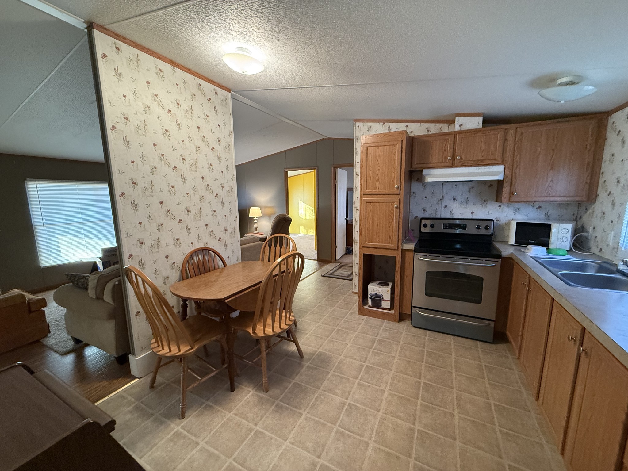 213 Alps Drive Hohenwald, TN 38462 - Photo 6 of 17 a kitchen with granite countertop a stove a sink a dining table and chairs
