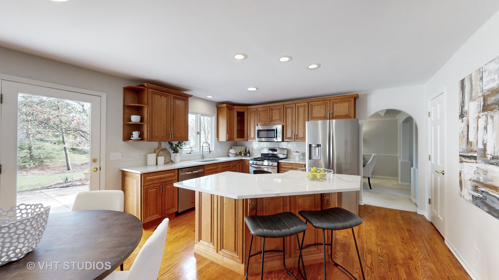 724 Sigmund Road Naperville, IL 60563 - Photo 13 of 44 a large kitchen with granite countertop a dining table chairs with wooden floor and cabinets
