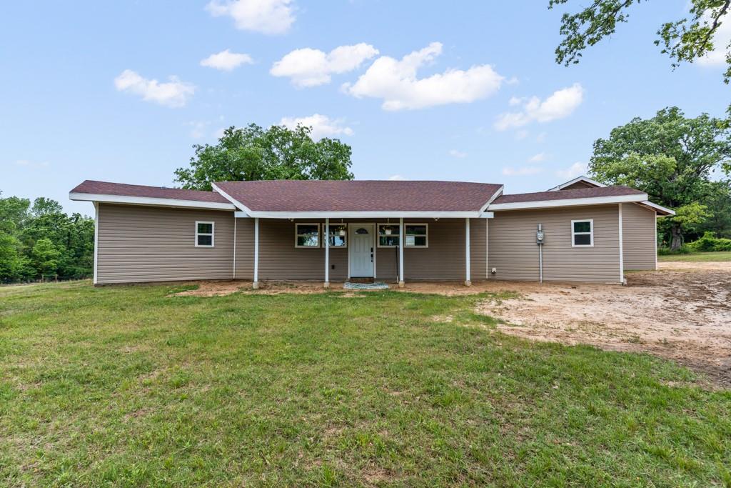 1129 Holly Road Gilmer, TX 75644 - Photo 2 of 31 Single-story residence featuring tan horizontal siding and a dark shingle roof