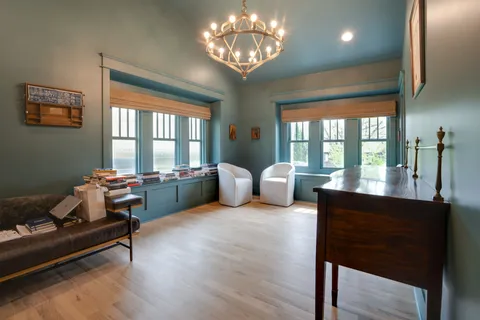 a view of a dining room with furniture a chandelier and wooden floor