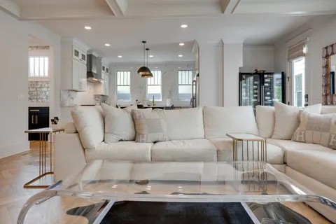 a kitchen with stainless steel appliances granite countertop a stove top oven a sink a dining table and chairs with wooden floor