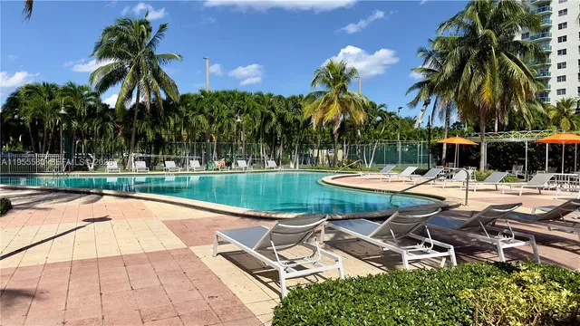 a row of palm trees in front of a house