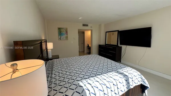 a bedroom with a bed and a flat screen tv