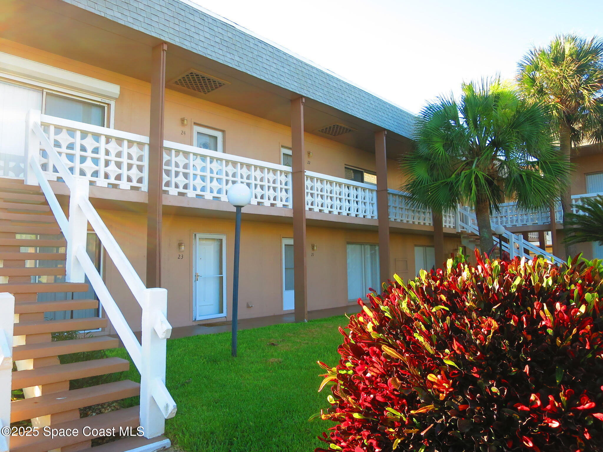 3150 North Atlantic Avenue, Unit 23330 Cocoa Beach, FL 32931 - Photo 2 of 18 a front view of a house with a yard