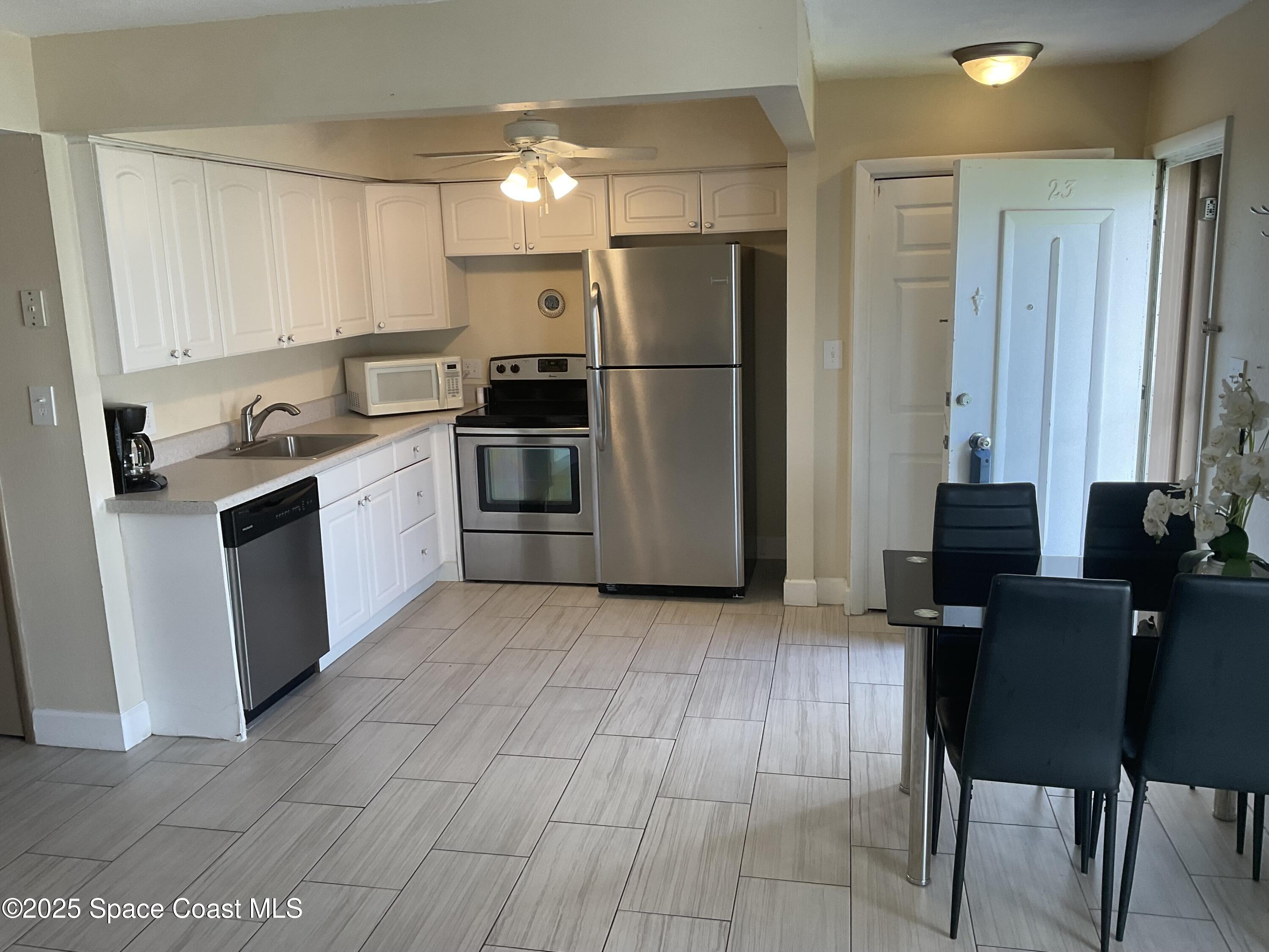 3150 North Atlantic Avenue, Unit 23330 Cocoa Beach, FL 32931 - Photo 5 of 18 a kitchen with stainless steel appliances granite countertop a refrigerator and a stove top oven