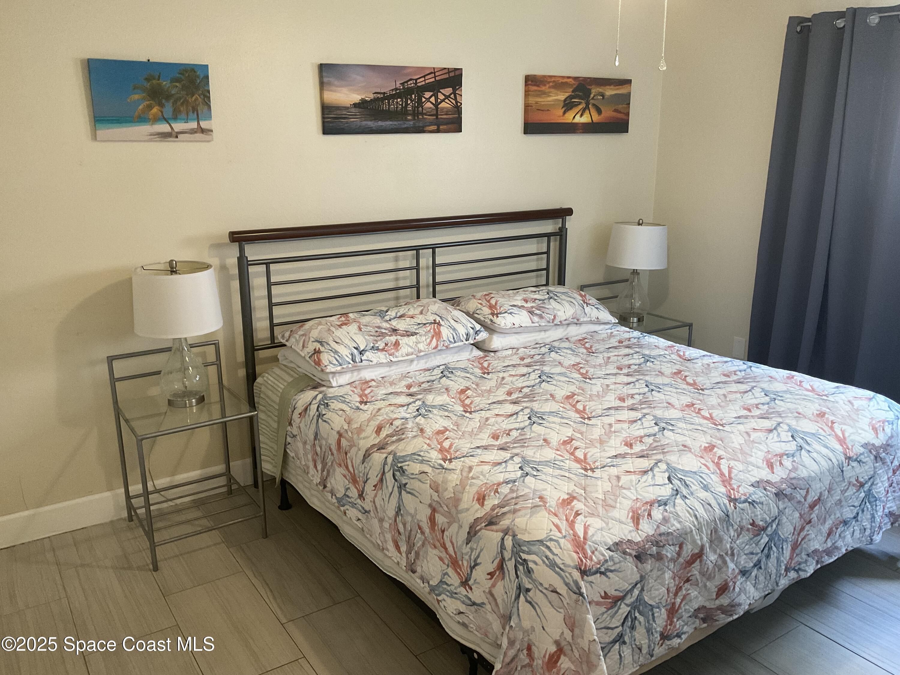 3150 North Atlantic Avenue, Unit 23330 Cocoa Beach, FL 32931 - Photo 6 of 18 a bedroom with a bed and painting on the wall