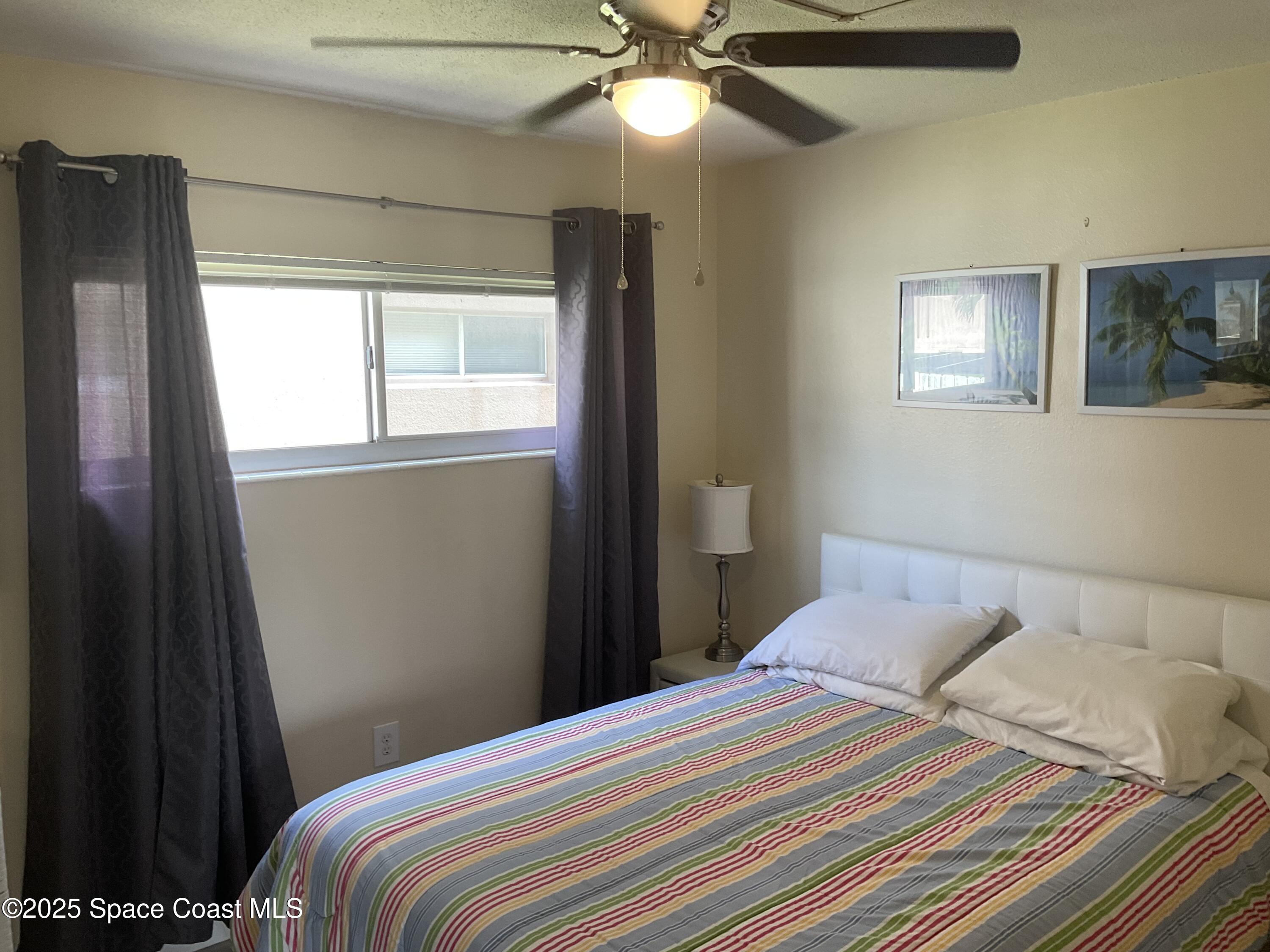 3150 North Atlantic Avenue, Unit 23330 Cocoa Beach, FL 32931 - Photo 7 of 18 a bedroom with a bed and a window