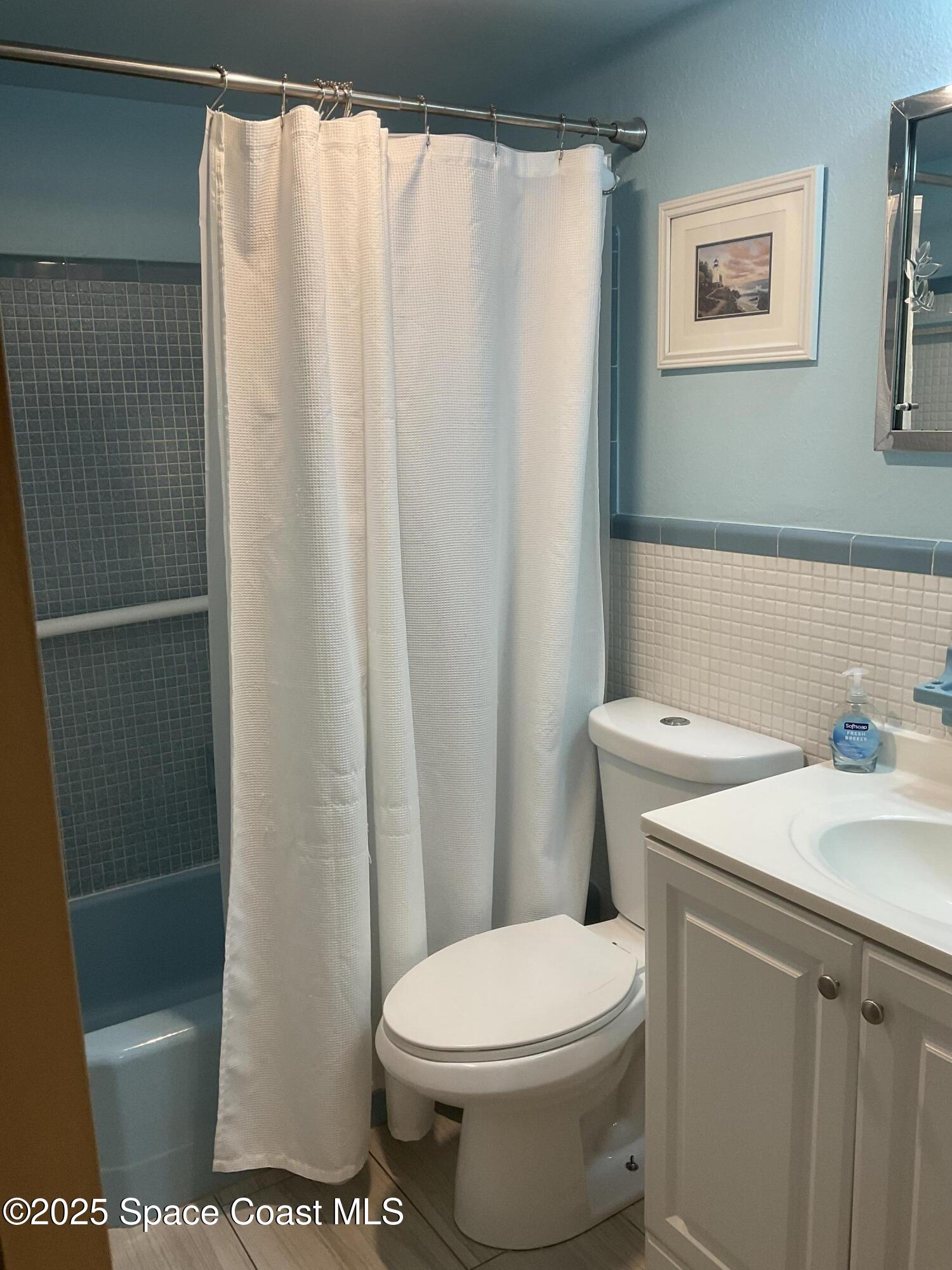 3150 North Atlantic Avenue, Unit 23330 Cocoa Beach, FL 32931 - Photo 8 of 18 a white toilet sitting next to a bathroom sink