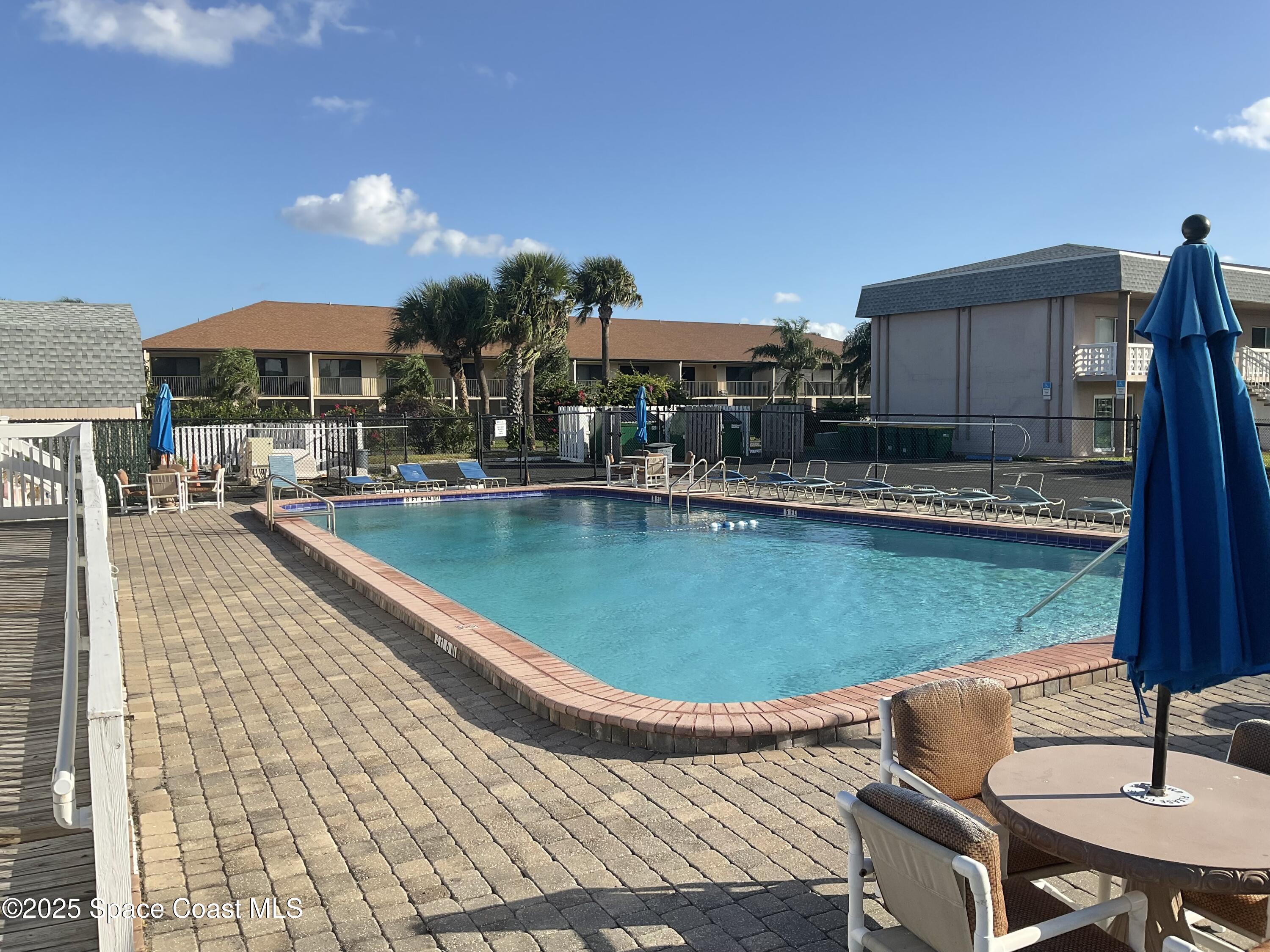 3150 North Atlantic Avenue, Unit 23330 Cocoa Beach, FL 32931 - Photo 9 of 18 a swimming pool with outdoor seating yard and barbeque oven