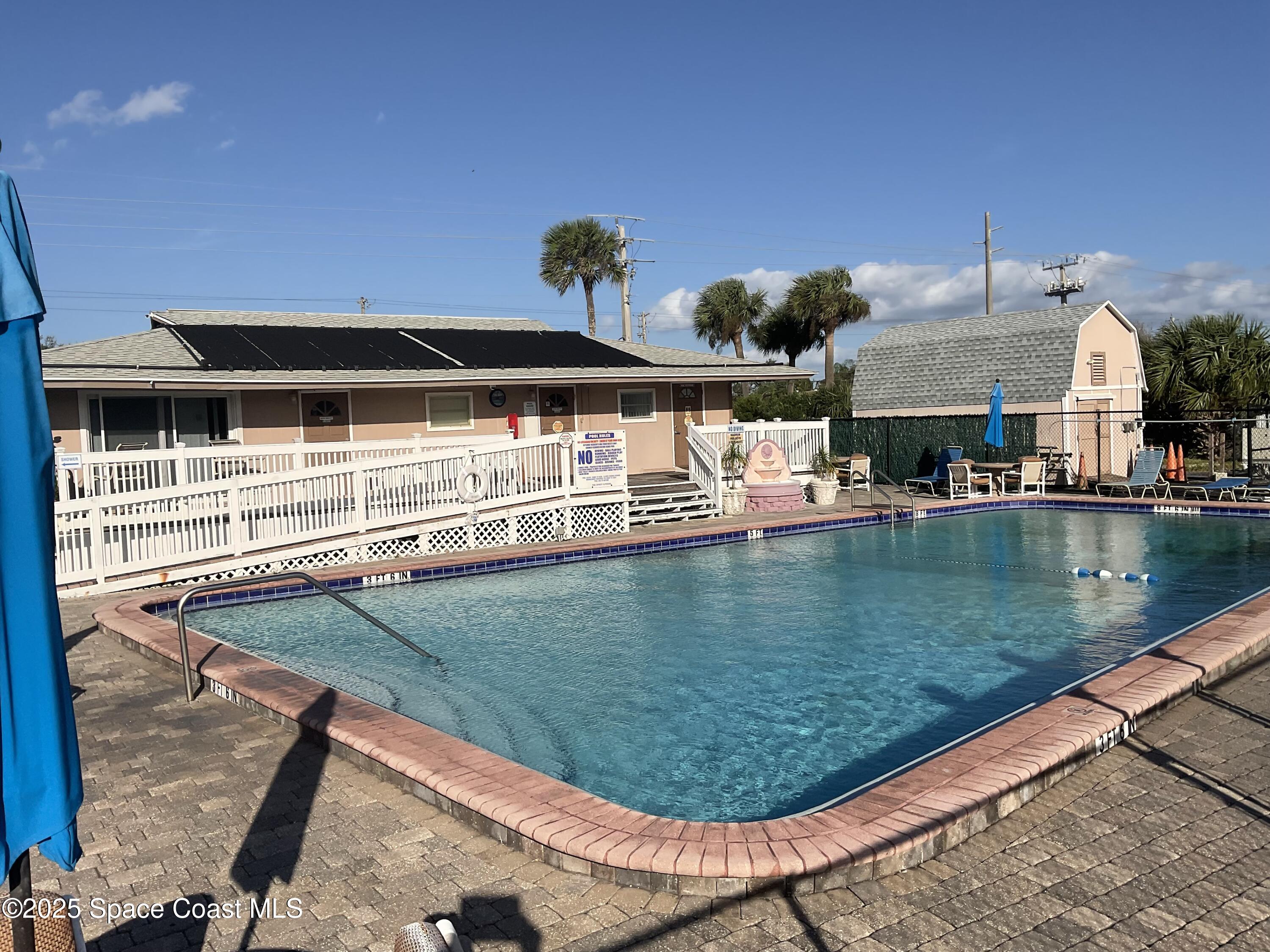 3150 North Atlantic Avenue, Unit 23330 Cocoa Beach, FL 32931 - Photo 10 of 18 a view of a swimming pool with outdoor seating