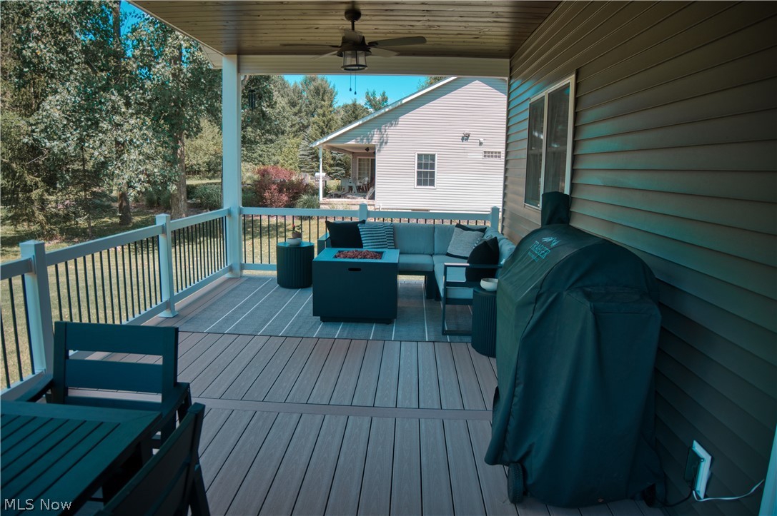 4553 Sharon Copley Road Medina, OH 44256 - Photo 21 of 32 Covered porch featuring wood-finish decking, white railings with black spindles, and a ceiling fan with integrated lighting