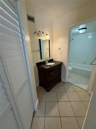 a bathroom with a granite countertop sink a toilet and mirror