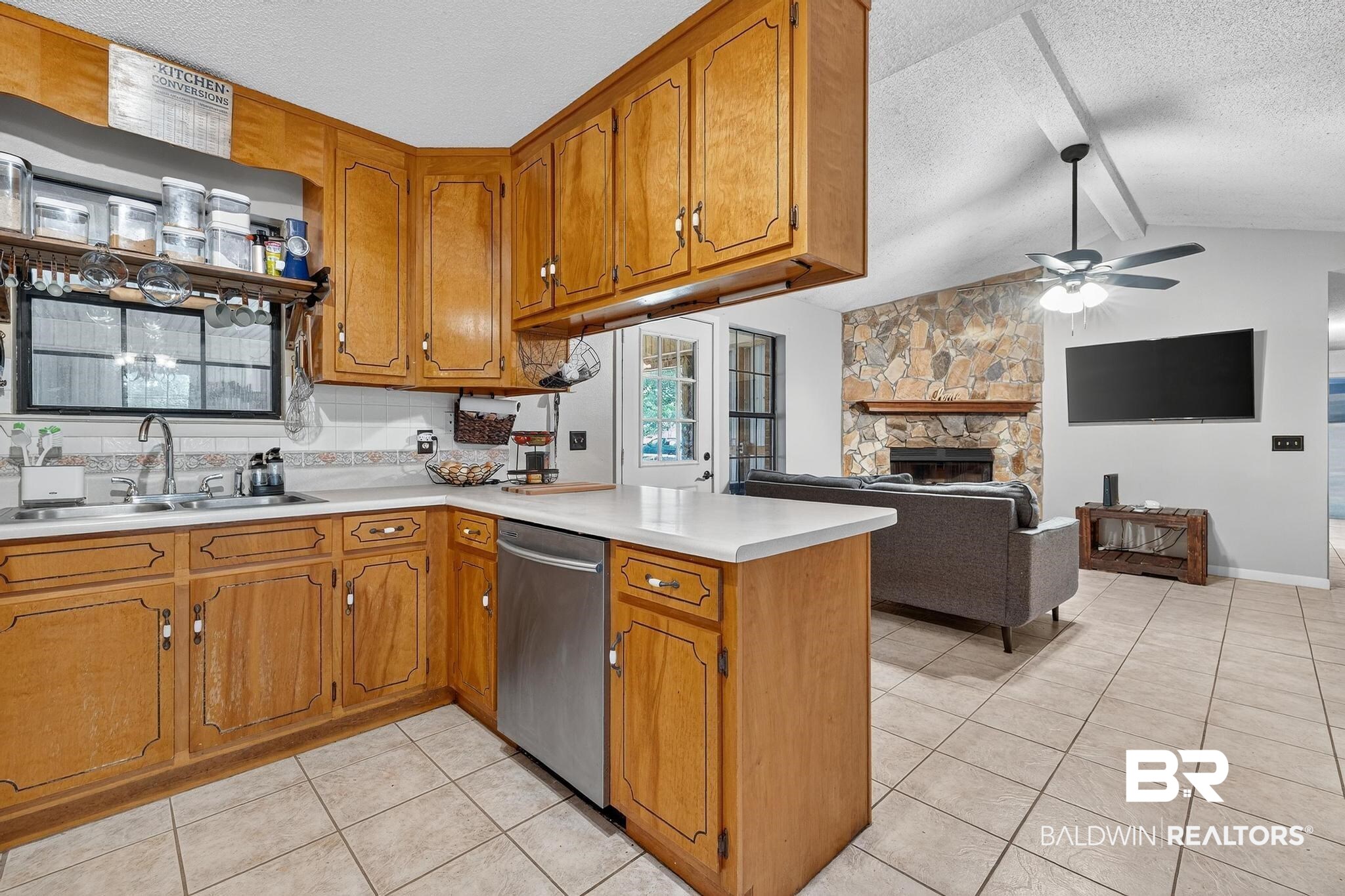 21895 2nd Street Silverhill, AL 36576 - Photo 22 of 43 Kitchen featuring a peninsula, light countertops, and brown cabinets