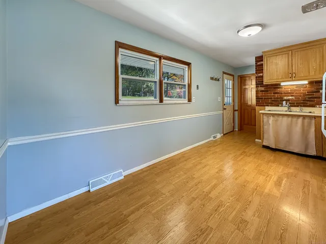 a view of a kitchen with wooden floor and electronic appliances