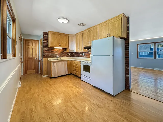 a kitchen with stainless steel appliances granite countertop a refrigerator a stove and a sink