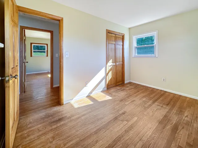a view of a room with wooden floor and a ceiling fan