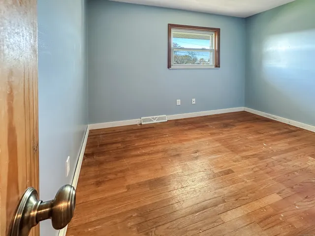 a view of a room with wooden floor and chair