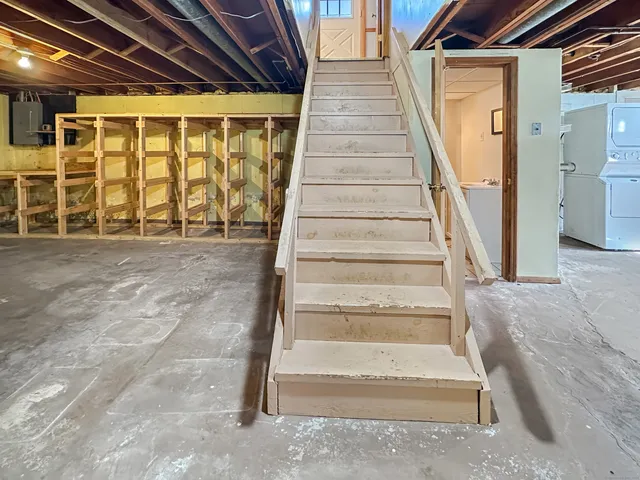 a view of staircase with white walls and a rug