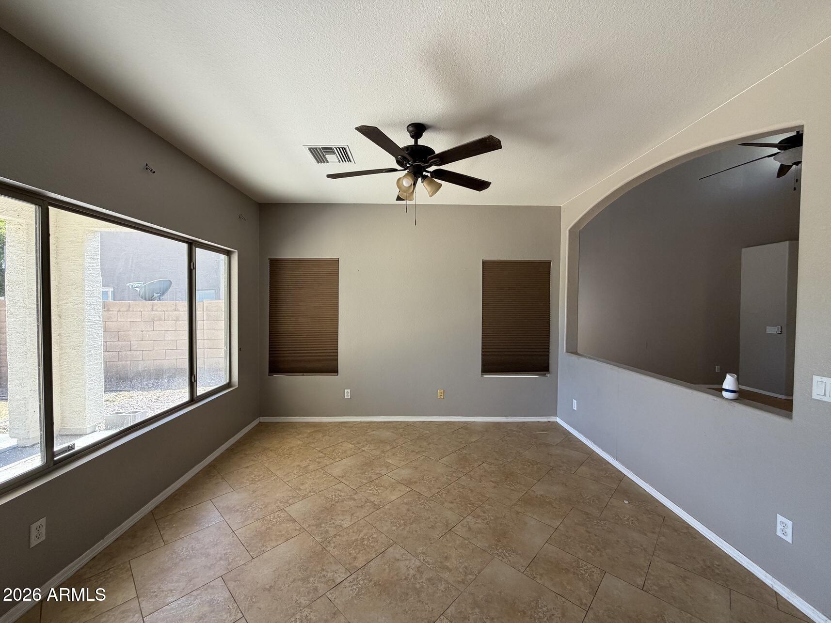10807 West Monte Vista Road Avondale, AZ 85392 - Photo 10 of 33 an empty room with windows and chandelier fan