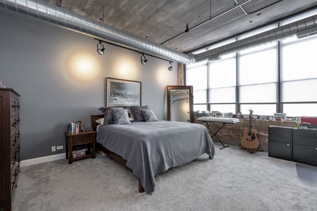 850 West Adams Street, Unit 6E Chicago, IL 60607 - Photo 8 of 14 a spacious bedroom with a bed and a dresser next to a window