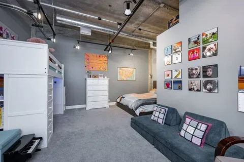 a living room with furniture and a refrigerator