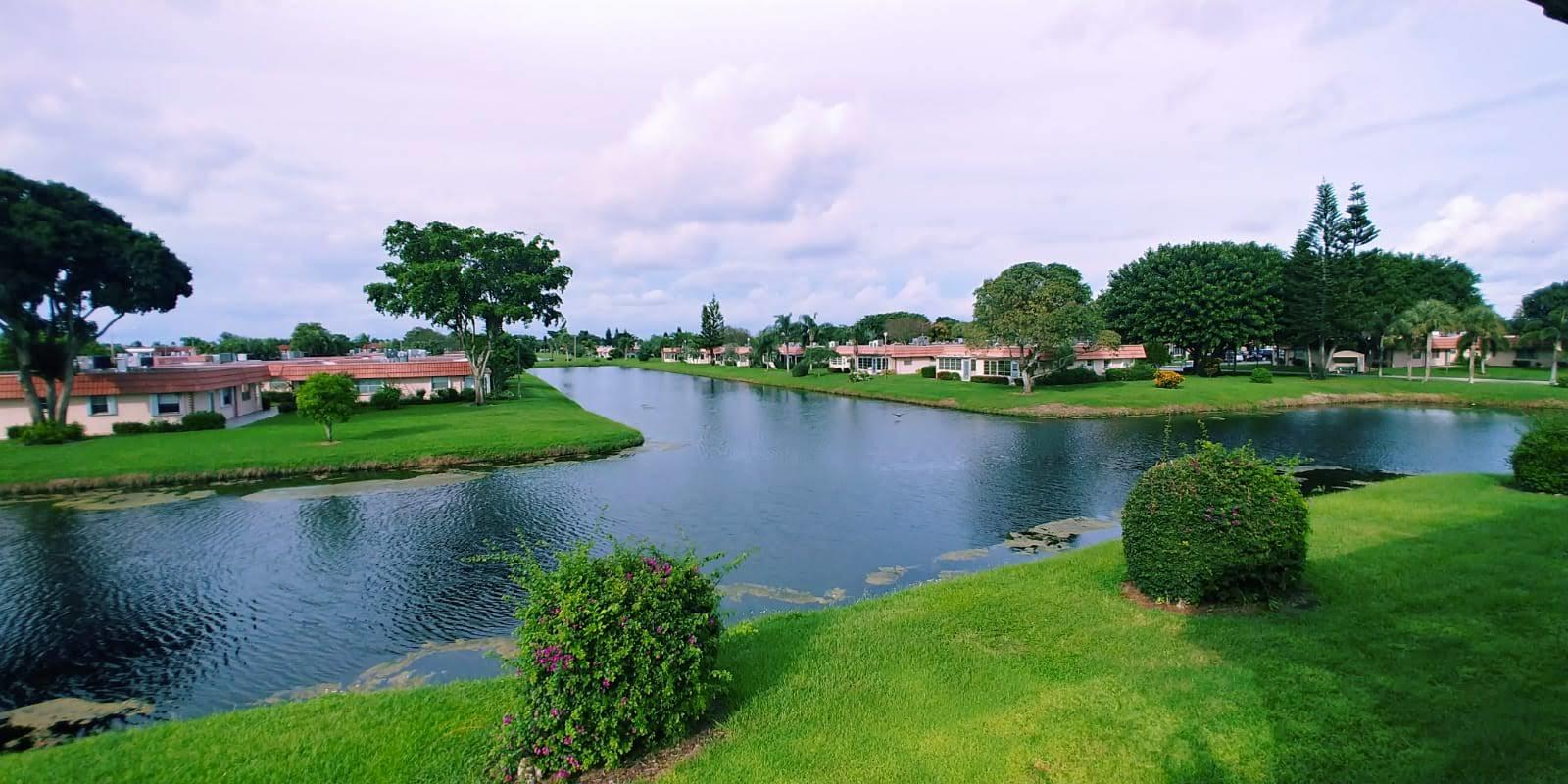 95 Monaco Boulevard, Unit B Delray Beach, FL 33446 - Photo 2 of 46 a lake view with a garden