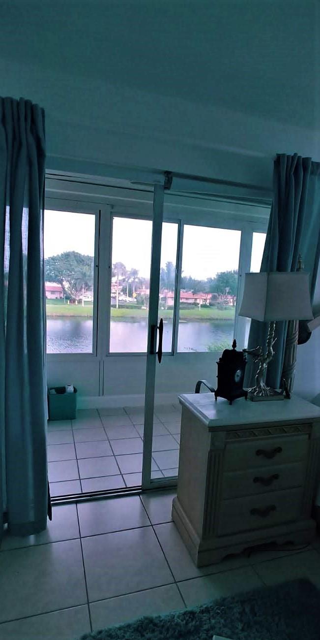 95 Monaco Boulevard, Unit B Delray Beach, FL 33446 - Photo 18 of 46 a living room with a fireplace and a floor to ceiling window