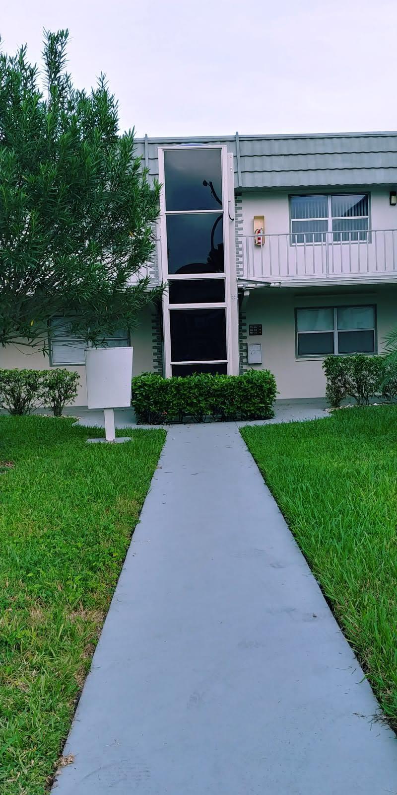 95 Monaco Boulevard, Unit B Delray Beach, FL 33446 - Photo 35 of 46 a front view of a house with a yard and garage