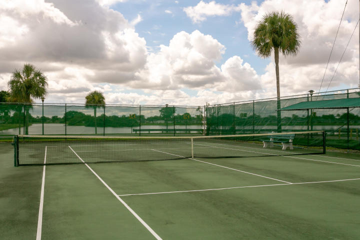 95 Monaco Boulevard, Unit B Delray Beach, FL 33446 - Photo 43 of 46 a view of tennis court with trees in the background