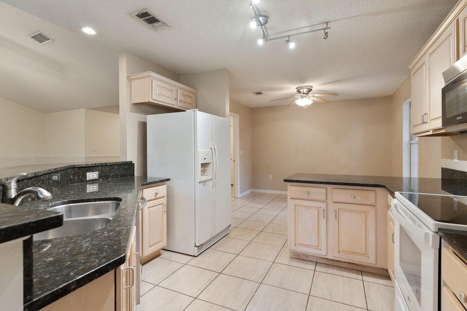 209 Warrior Street Crestview, FL 32536 - Photo 8 of 18 a kitchen with stainless steel appliances granite countertop a refrigerator a stove and a sink