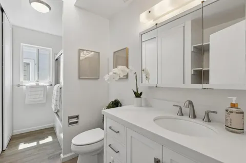 a bathroom with a granite countertop toilet sink and a mirror