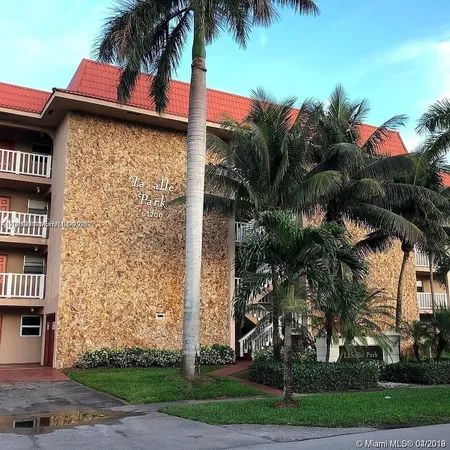 a palm tree sitting in front of a house with a yard