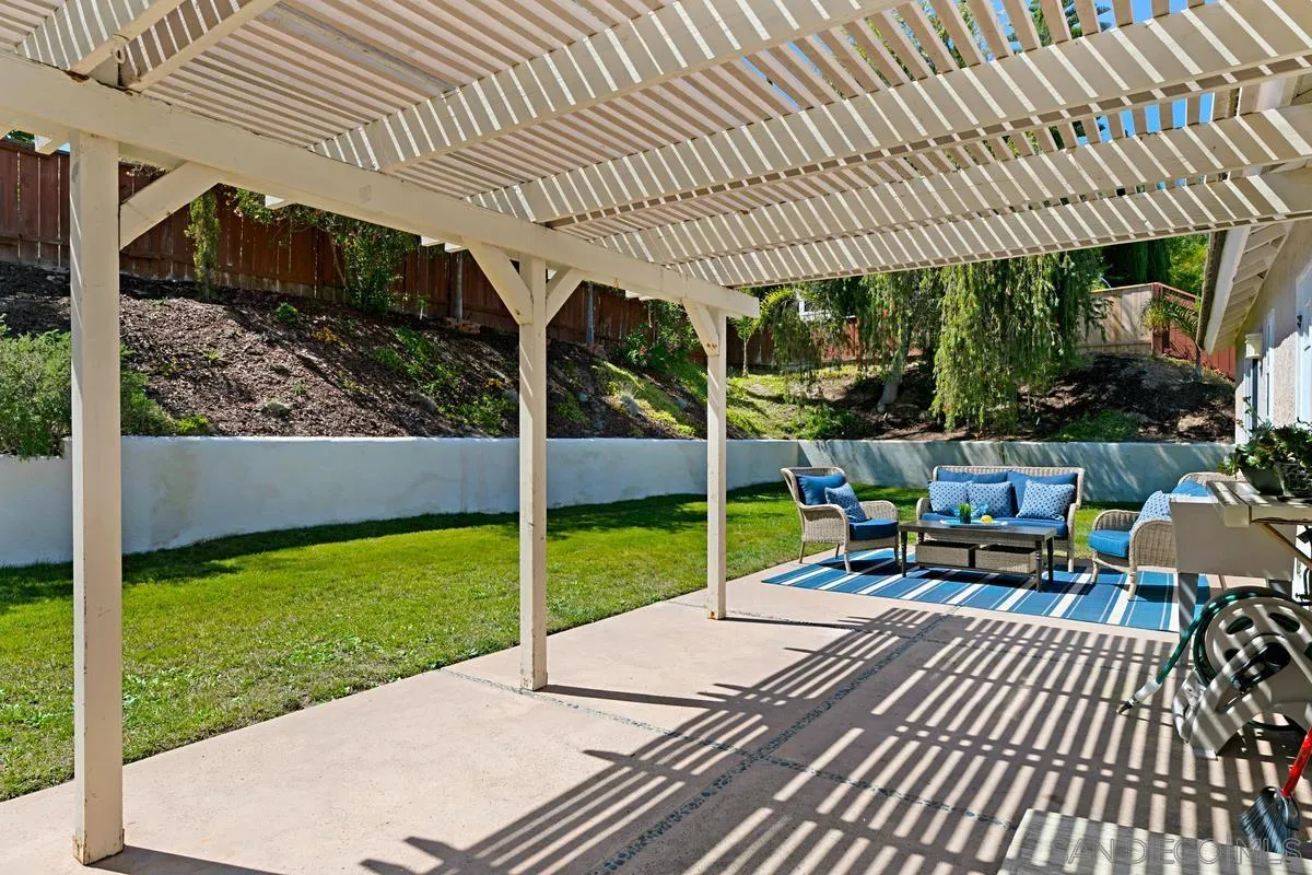 574 Gardendale Road Encinitas, CA 92024 - Photo 29 of 53 a view of a patio with table and chairs potted plants with wooden floor and fence