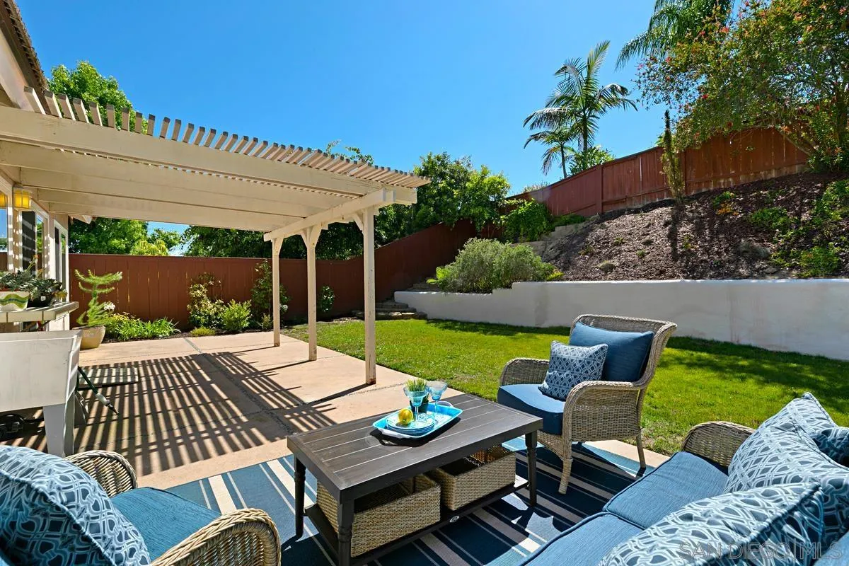 574 Gardendale Road Encinitas, CA 92024 - Photo 30 of 53 a view of a patio with couches table and chairs under an umbrella