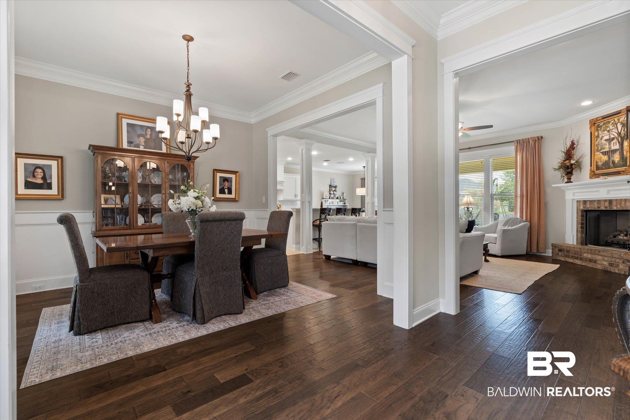 24821 Austin Road Daphne, AL 36526 - Photo 3 of 24 Dining area with wood finished floors, a chandelier, crown molding, a fireplace, and ceiling fan
