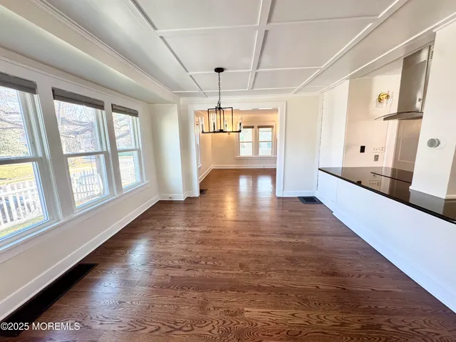 a view of a house with wooden deck and a bench