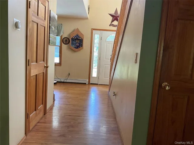 a view of a hallway with wooden floor and stairs