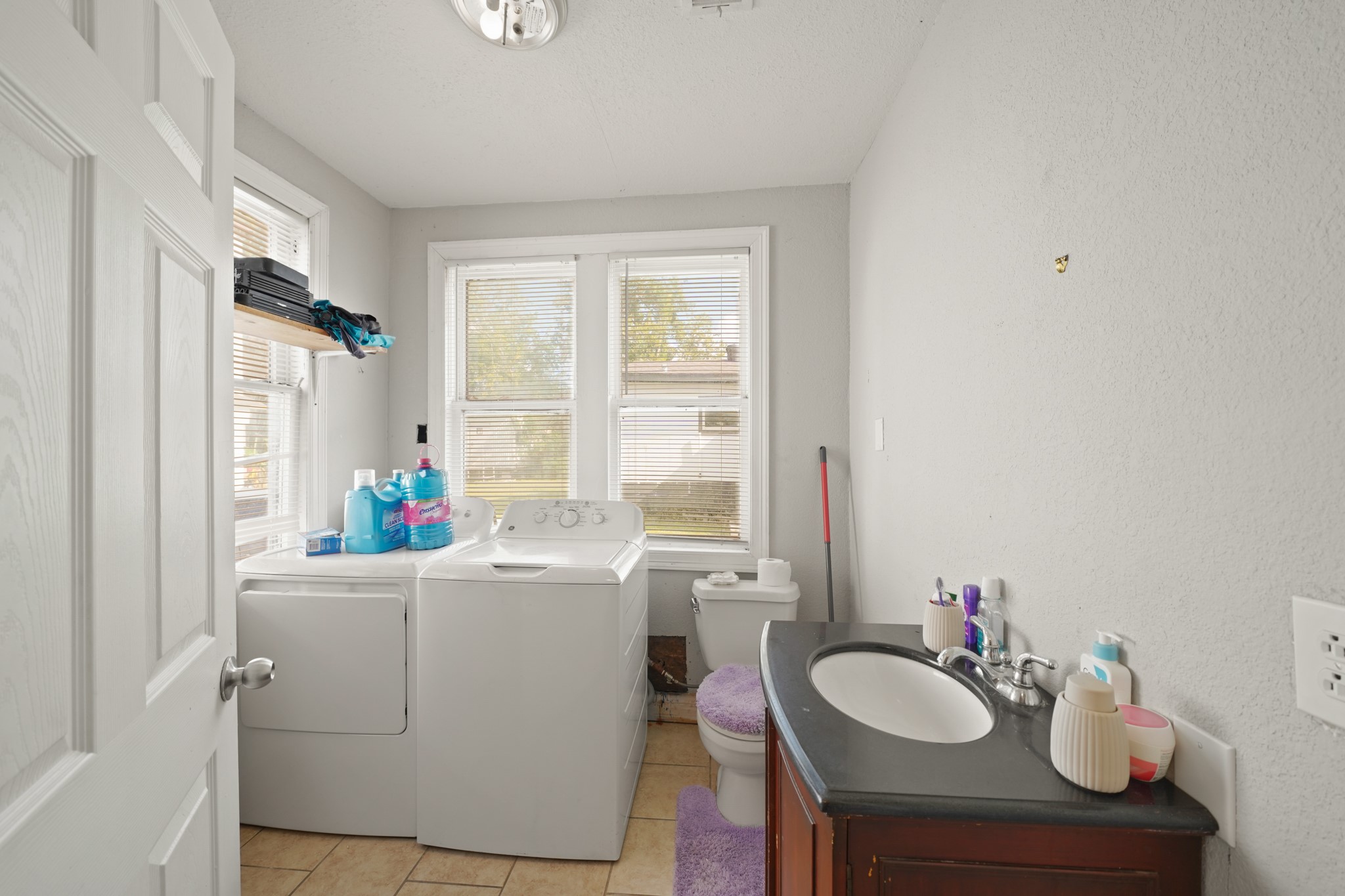 5307 Crane Street Houston, TX 77026 - Photo 25 of 41 4001 Lockwood Dr. Bright utility room featuring washer/dryer, full sink vanity, and ample natural light from large windows.