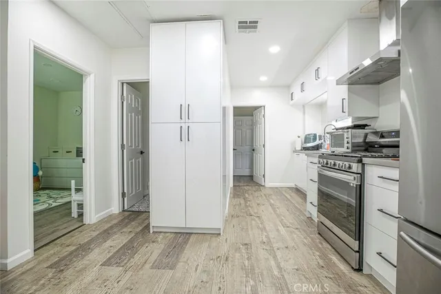 a kitchen with stainless steel appliances granite countertop a refrigerator and a stove top oven