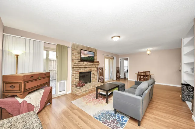 a living room with furniture fireplace and wood floor
