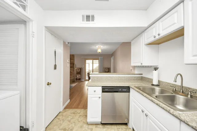 a kitchen with granite countertop white cabinets and white appliances