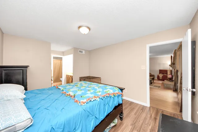 a bedroom with a bed and wooden floor