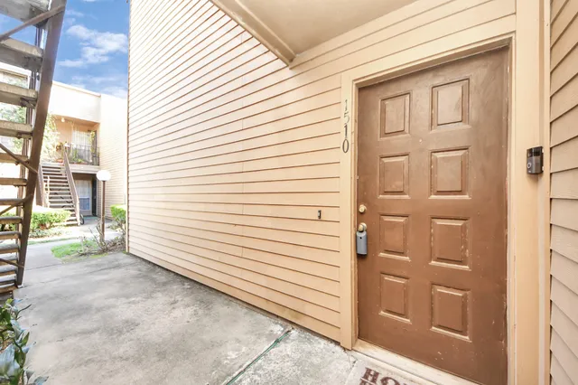 a view of a porch with a door and wooden floor