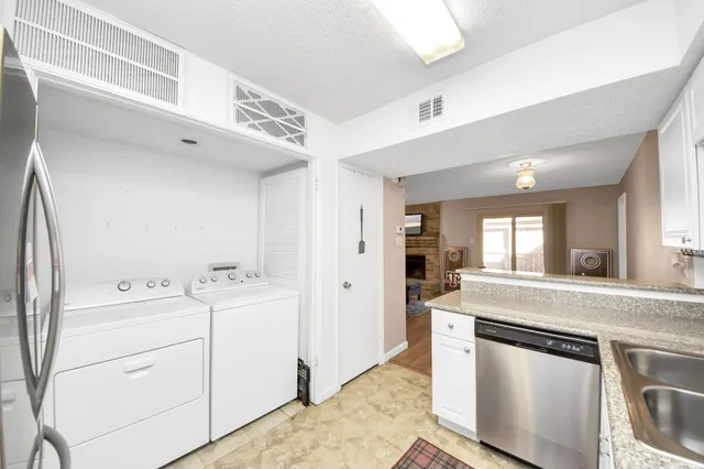 a kitchen with white cabinets and sink
