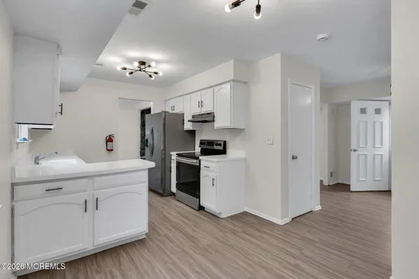 a kitchen with cabinets and wooden floor