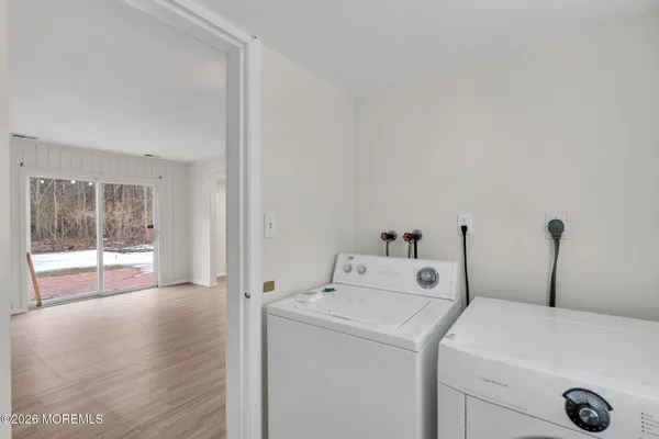 a view of washer and dryer with bathroom in the background