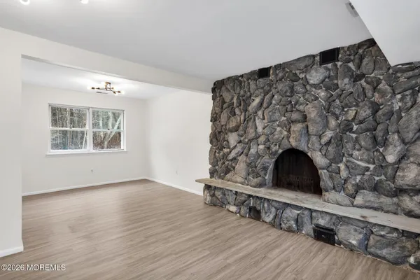 a living room with stainless steel appliances wooden floor and a fireplace